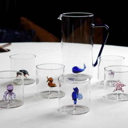 Pichet et verre a eau avec une figurine à l'intérieur